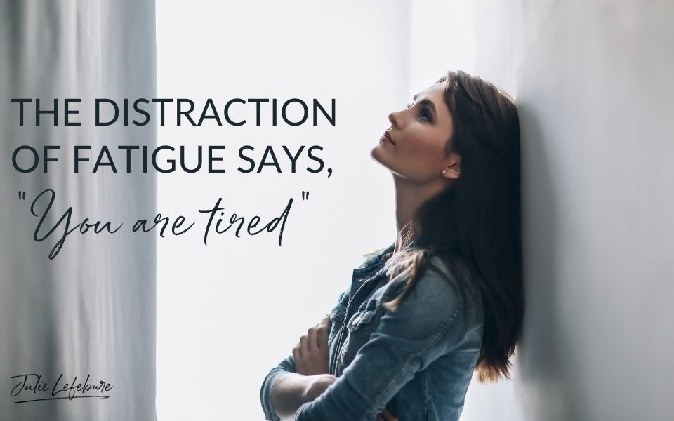 The Distraction of Fatigue Says, "You Are Tired" | woman with arms crossed, standing next to wall looking up tired