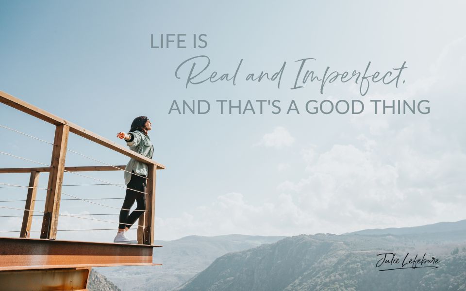 Life Is Real and Imperfect, and That's a Good Thing | woman standing by a fence looking over mountains with arms stretched out