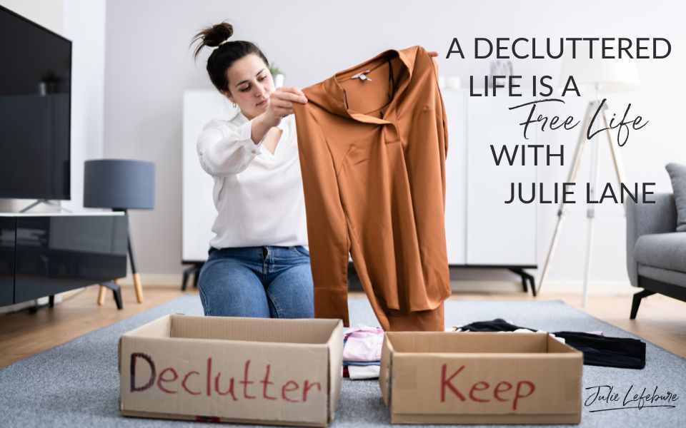 A Decluttered Life Is a Free Life with Julie Lane | woman sitting on floor next to a box labeled Declutter and a box labeled Keep, holding up a blouse