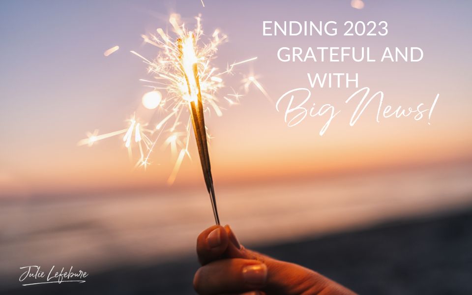 Ending 2023 Grateful and With Big News | woman's hand holding a sparkler with water in the background